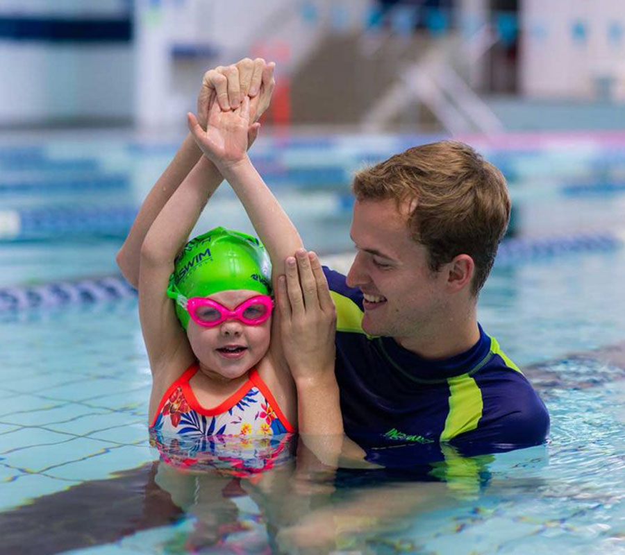 Instructor showing a student how to position their body during Intensive swimming lessons